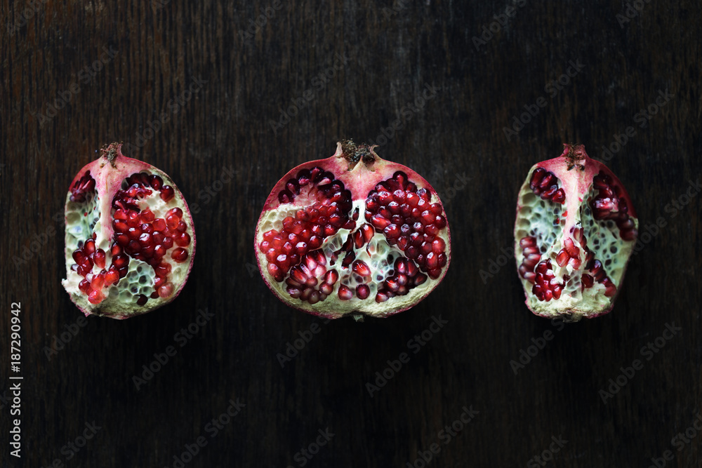 Pomegranate slices on dark wooden table, top view Pomegranate slices on dark wooden table, top view