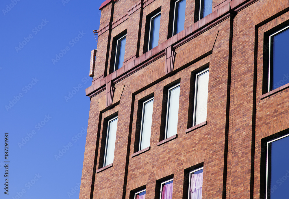 A view of a brick building in NYC in a blue clear sky