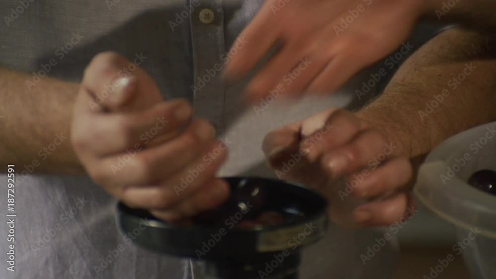 Two chefs extracting the juice from grapes with the manual wine press