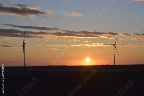 日の出と風力発電の風車