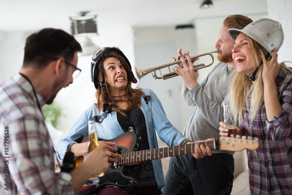 Fototapeta premium Friends having fun and partying in house and playing music