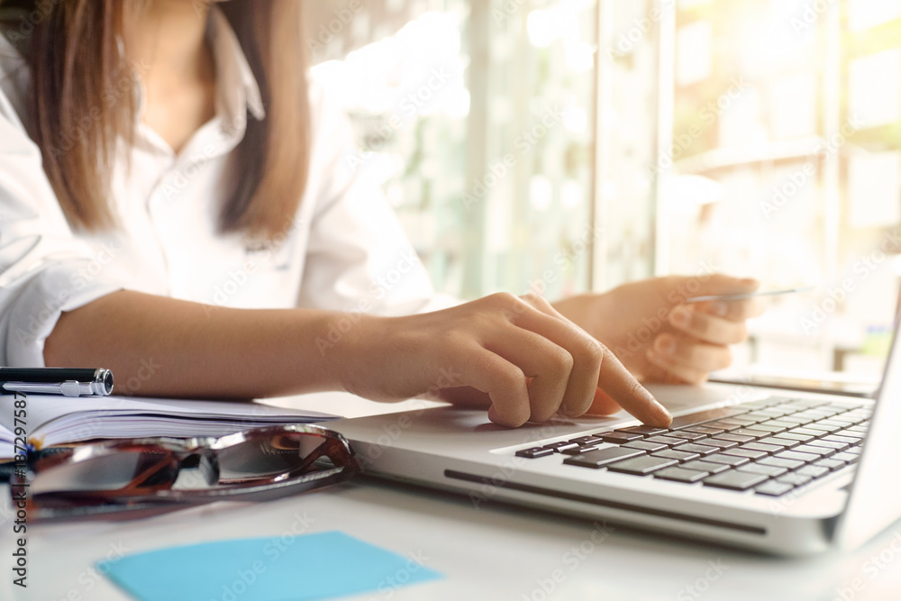 Shopping online concept,Young woman using laptop computer and holding credit card with shopping on computer. Shopping online concept,Young woman using laptop computer and holding credit card with shopping on computer.