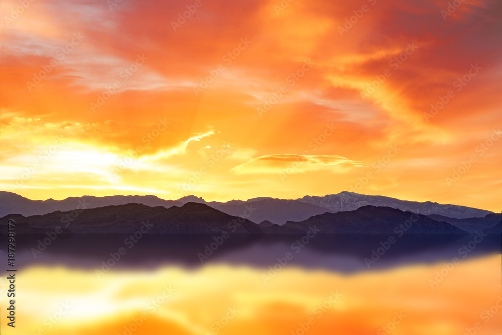 scenic dawn on a mountain range reflecting in water