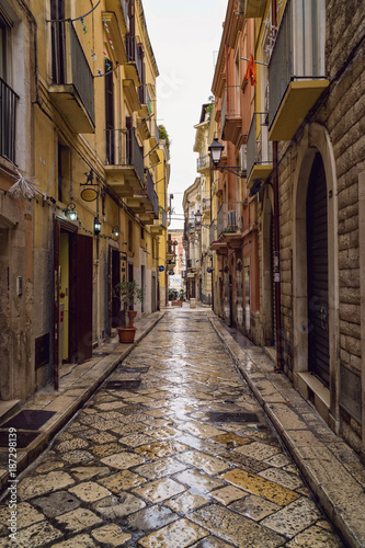 Fototapeta Naklejka Na Ścianę i Meble -  Old medieval street and pavement wet from rain in the Italian city of Bari