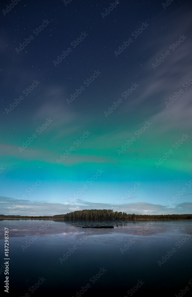 Northern Lights behind fast moving clouds in Kurjenrahka National Park, Finland