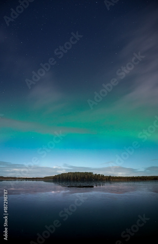 Northern Lights behind fast moving clouds in Kurjenrahka National Park, Finland