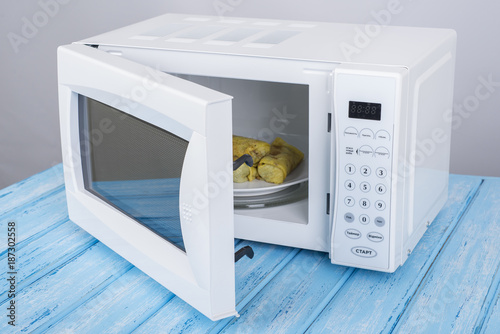 white microwave oven, on a blue wooden surface for heating food