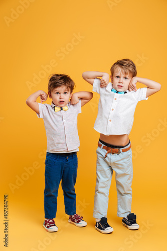Funny little children brothers standing isolated