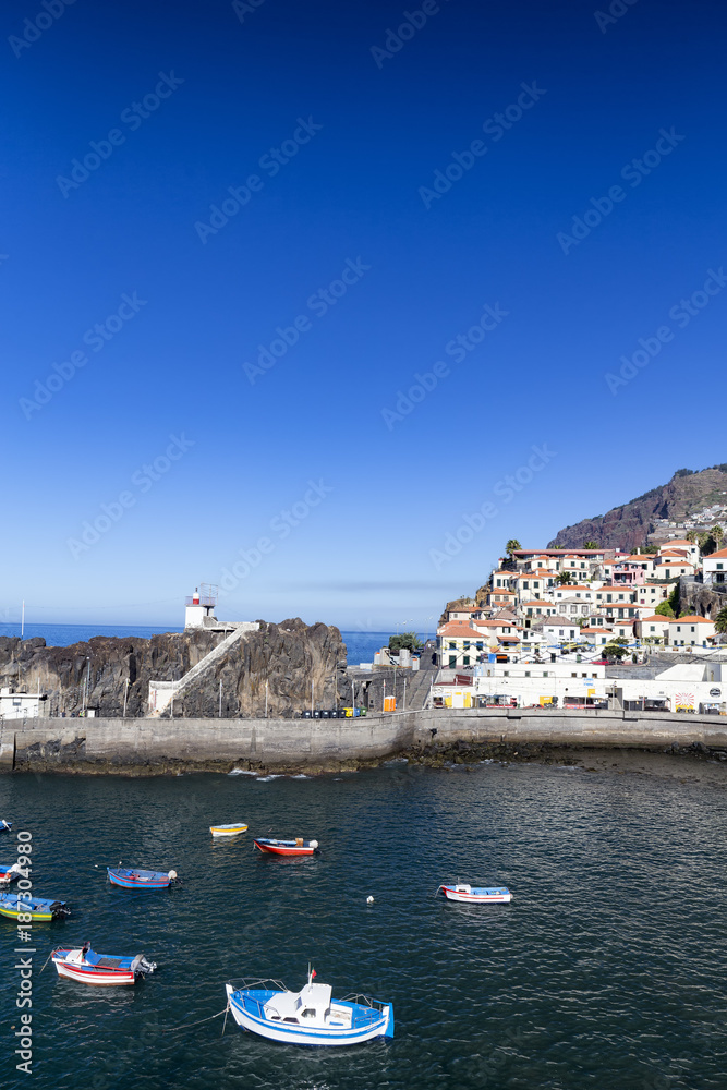 Portrait view of boats and houses in the  harbor of Camara de Lobos in Madeira, Portugal