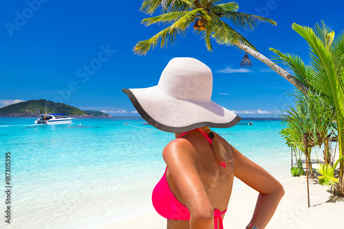 Beautiful woman in white hat on the tropical beach