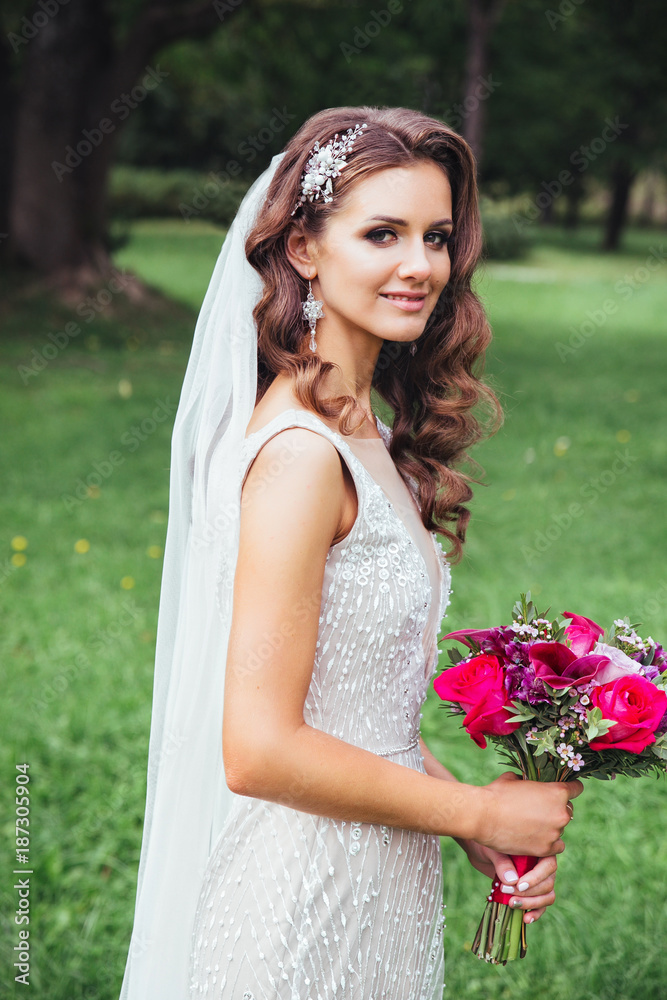 Beautiful bride outdoors in a park . Bridal style Beautiful bride outdoors in a park . Bridal style