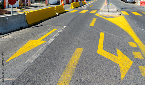 Yellow temporary lane markings at a crossroad near a construction site.