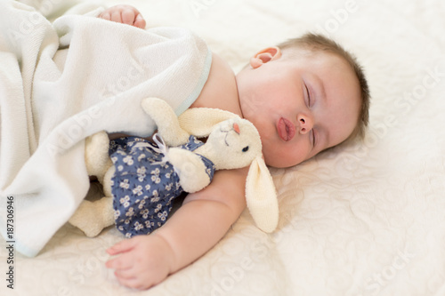 Cute little baby with toy sleeping on bed at home © Oksana Kuzmina