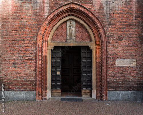 brick facade with ogival portal of a fifteenth-century church of Milan, Italy © gpriccardi