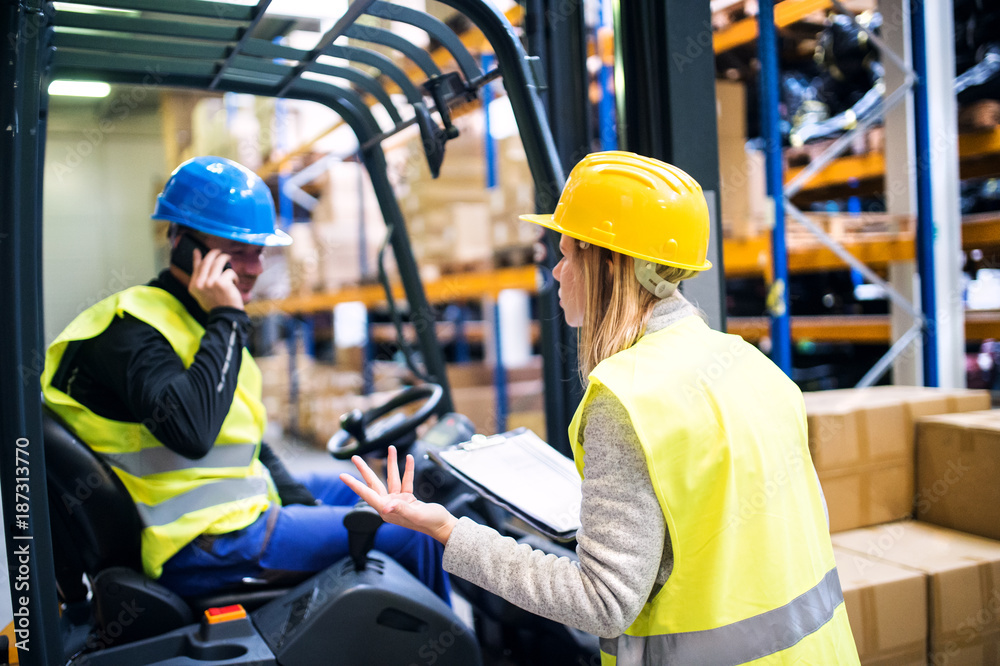 Young warehouse workers working together. Young warehouse workers working together.