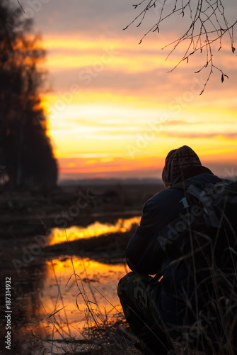 a professional photographer takes a picture of winter sunset,