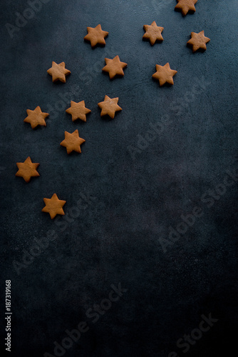 Christmas gingerbread star cookies on the dark blue surface, top view. 