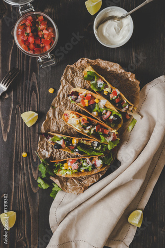 Mexican vegetarian tacos with salsa and avocado on the wooden background, top view. Copy space