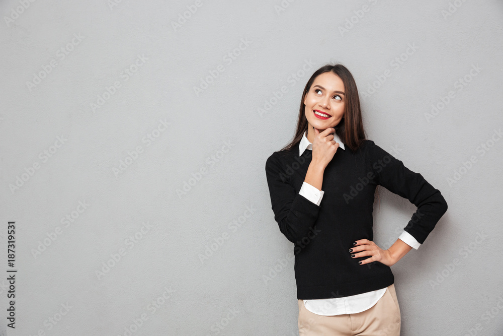 Pensive smiling woman in business clothes with arm on hip Pensive smiling woman in business clothes with arm on hip
