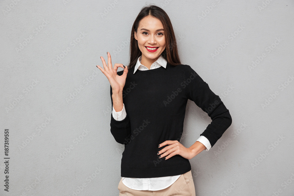 Cheerful asian woman in business clothes with arm on hip Cheerful asian woman in business clothes with arm on hip