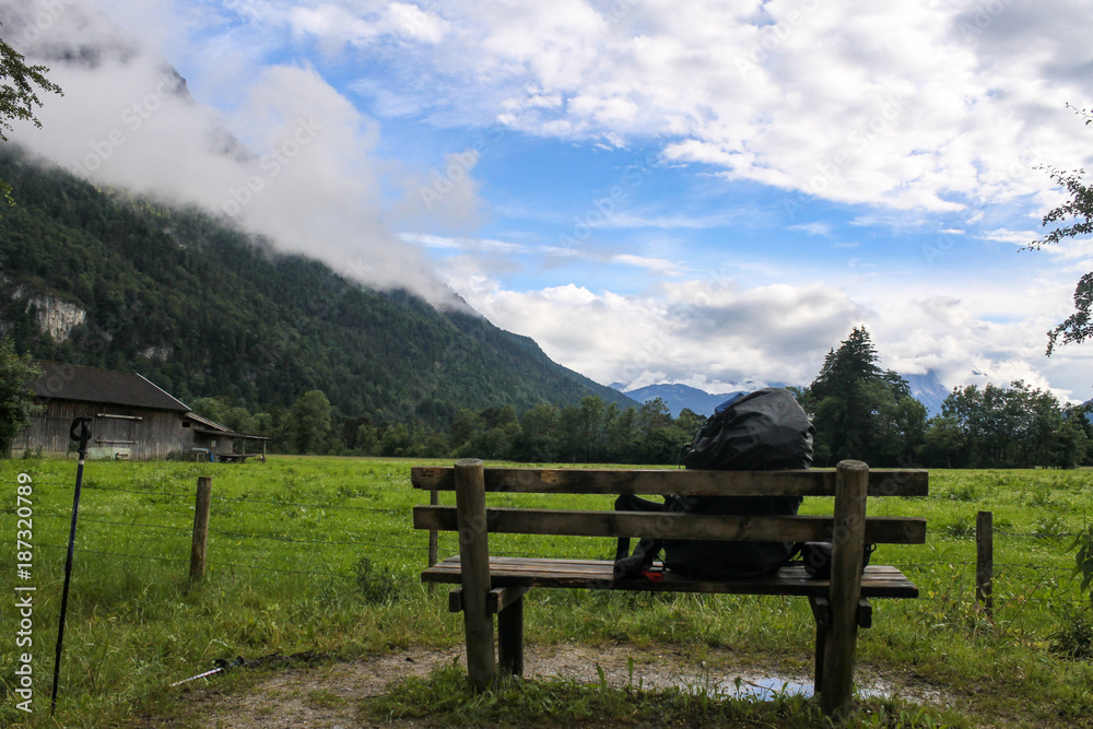 Backpack  on bench beautiful mountain view Bavaria Germany Alps