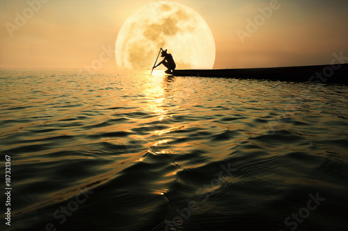 Fishermen on fishing boats stay in the river at night, the full moon is filled with the light of the moon.
