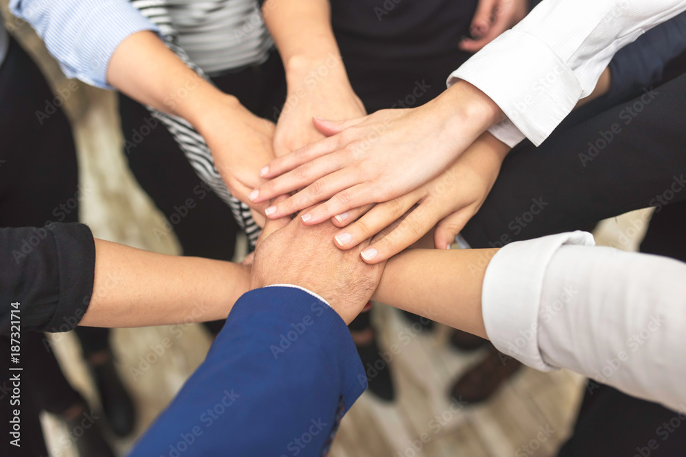 view of business partners hands on top of each other symbolizing teamwork view of business partners hands on top of each other symbolizing teamwork