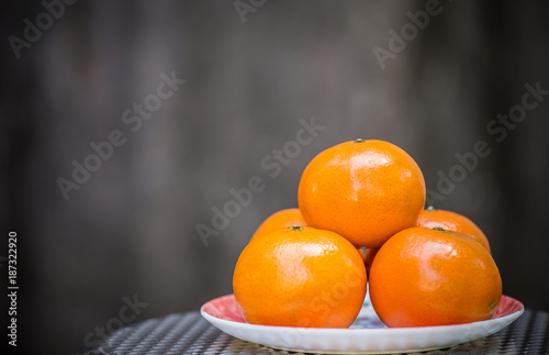 Orange in plate with gray background.