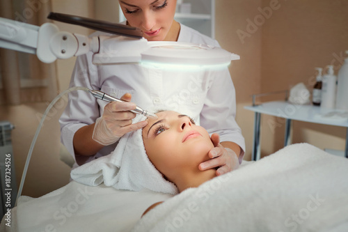 Woman on facial skincare procedure. Hardware cosmetology.