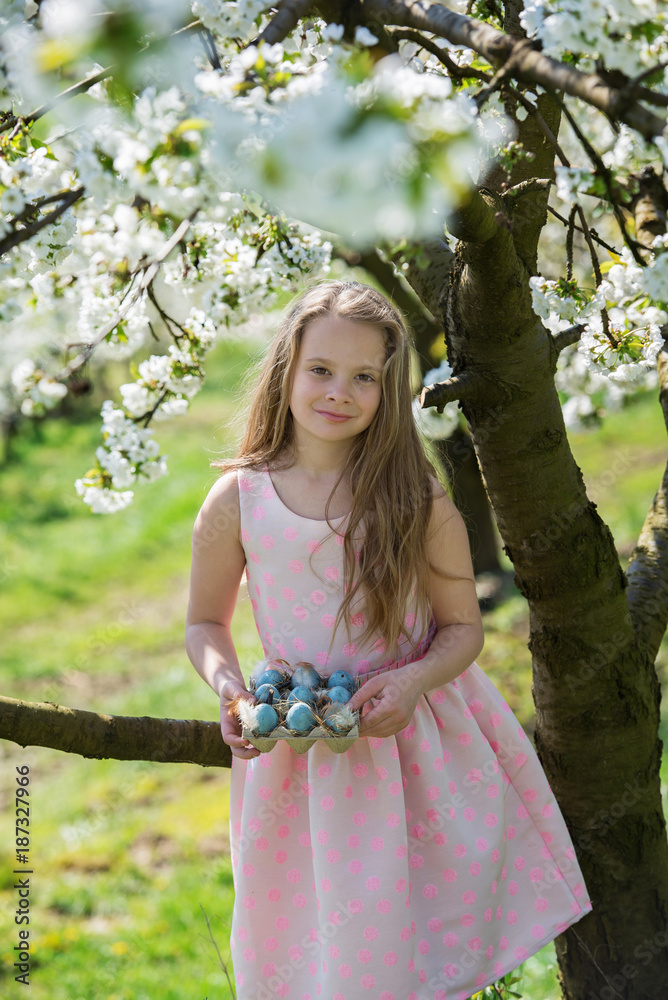 Adorable little girl with easter eggs in blossoming cherry garden Adorable little girl with easter eggs in blossoming cherry garden
