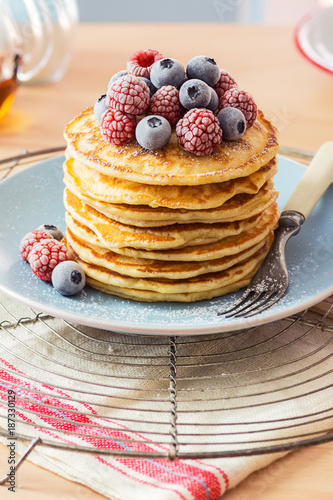 Stack of Pancakes Topped with Chilled Raspberries and Blueberries and Powdered Sugar