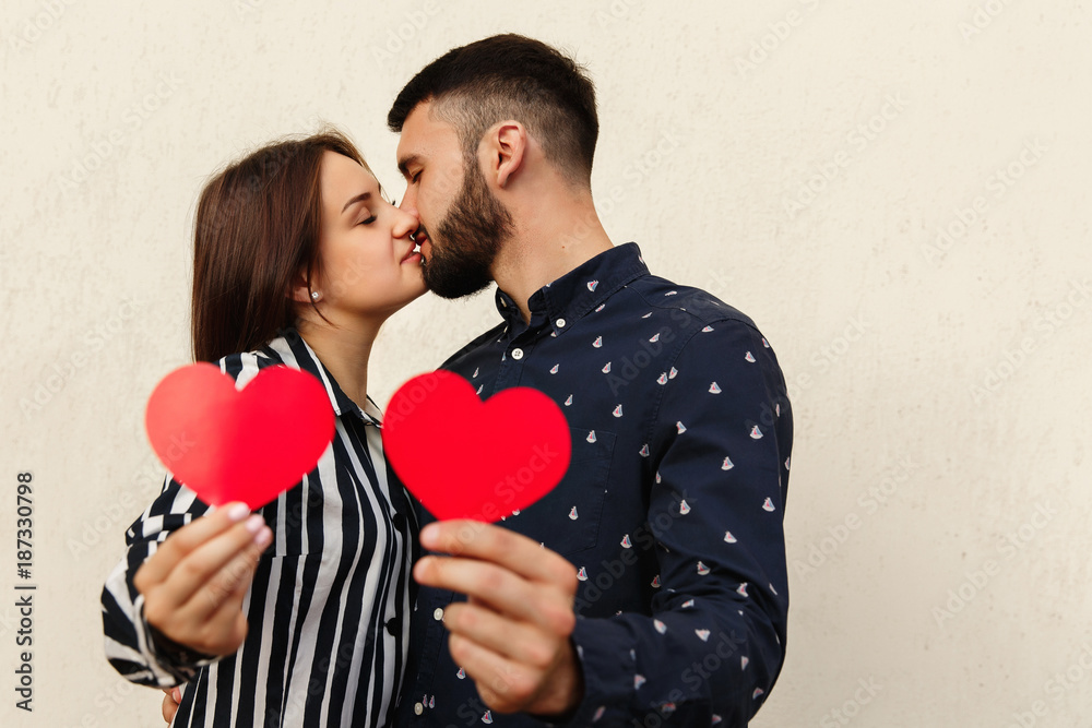 Kiss and love concept. Couple in love holding two red hearts. Valentines day-14 February Kiss and love concept. Couple in love holding two red hearts. Valentines day-14 February