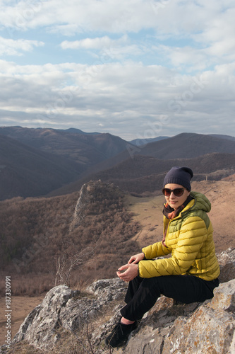 Adult woman hiking on hills on a sunny winter day