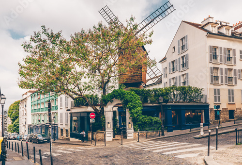 View of cozy street with old mill in quarter Montmartre in Paris, France