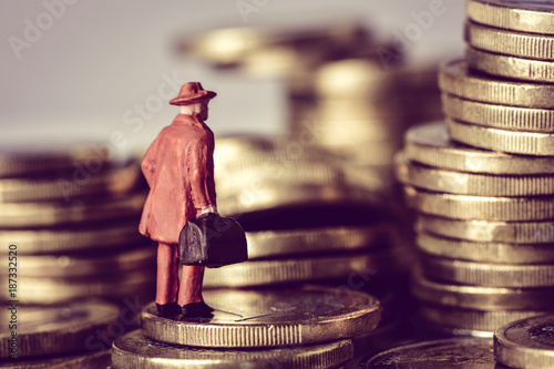 miniature traveler on a pile of euro coins photo