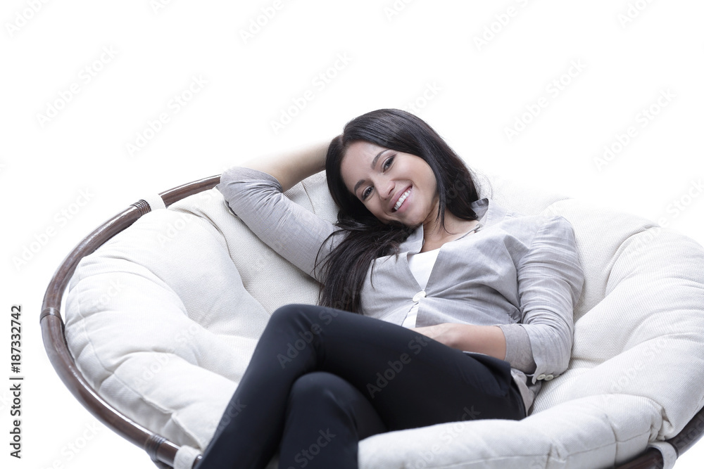 young woman sitting in a comfortable soft big armchair