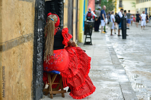 Photography The resident of Havana in the traditional dress is sitting in front of the colon