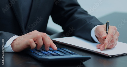 businessman uses a calculator for calculations
