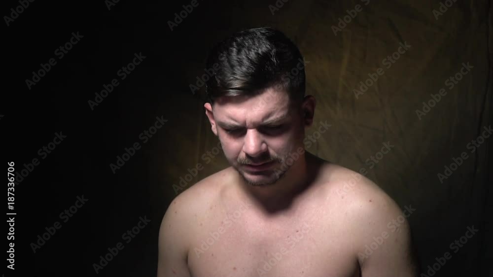 A man tiredly rubs his face and laughs A man tiredly rubs his face and laughs