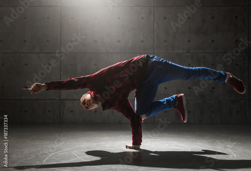 Young stylish male breakdancer posing in studio photo