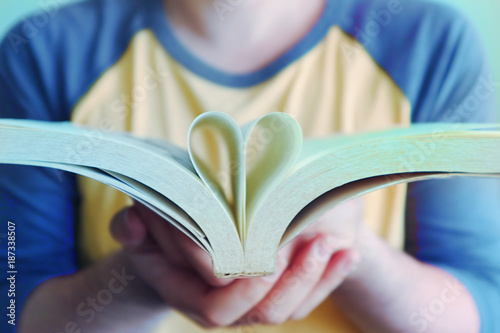 Book on hand and create shape heart. photo