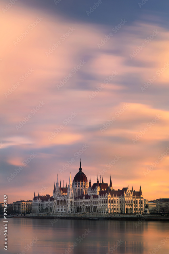 View of the parliament on the Danube river with romantic clouds during sunrise