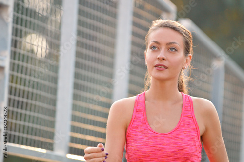 Portrait of a young woman running in urban environment