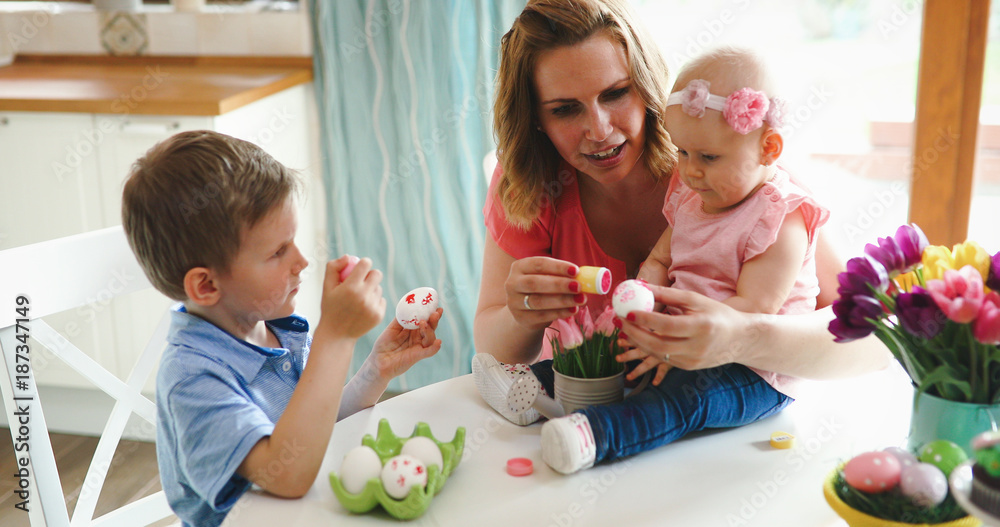 Mother and children painting colorful eggs Mother and children painting colorful eggs