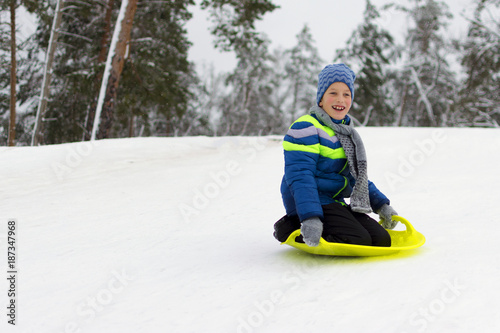 Kid flies down a hill on plate for driving on snow