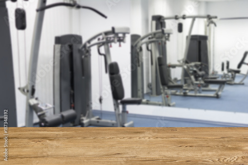 Blur fitness gym background and wooden desk space