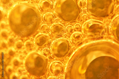 Golden background with big and small gold bubbles oil inside a gold liquid