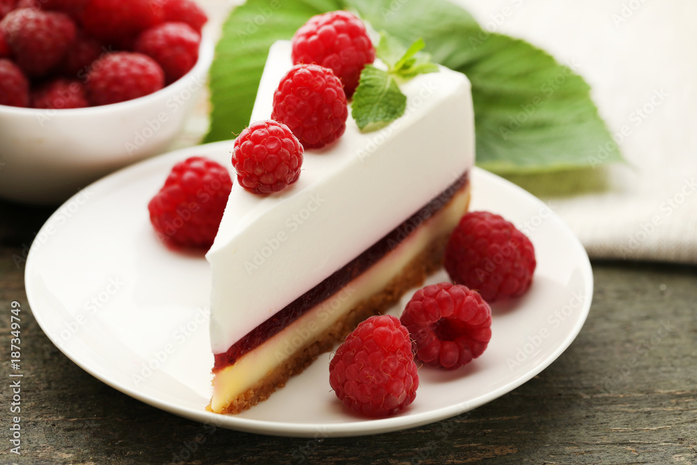 Tasty raspberry cheesecake in plate on wooden table Tasty raspberry cheesecake in plate on wooden table