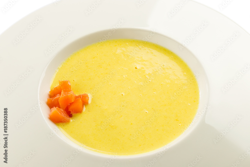 Cheese cream soup with salmon on white plate isolated on white Cheese cream soup with salmon on white plate isolated on white