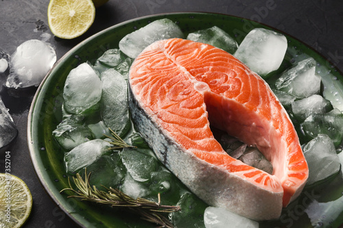 Fresh salmon with ice at dark background